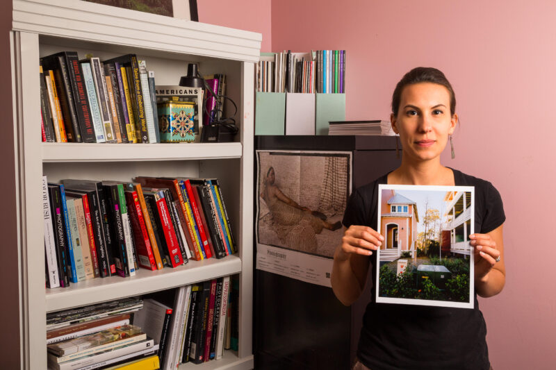 A photography professor in her office, holding one of her photos